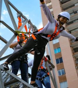 cursos de alturas en Bogotá con personal femenino realizando ejercicios de posicionamiento en andamios multidireccionales.