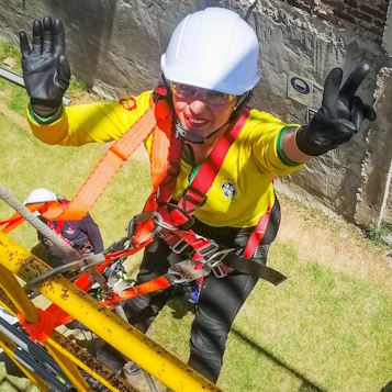 cursos de alturas en Bogotá con operaria usando equipo de protección anticaídas integral en jornada de práctica.